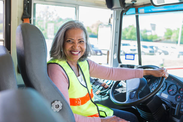 a cheerful african american teacher is also the elementary school bus driver.